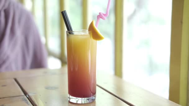 vidro de bebidas cor-de-laranja em uma mesa de café  - Filmagem, Vídeo