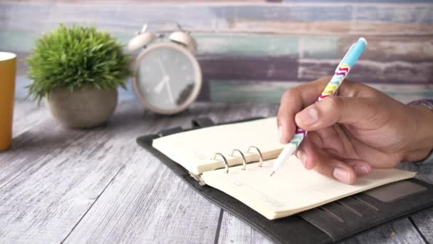 zbliżenie człowiek ręka pisanie na notatnik. - Materiał filmowy, wideo