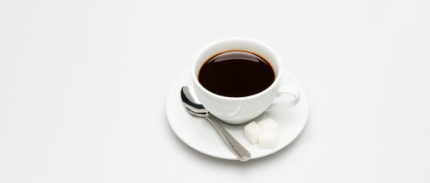 kopje verse koffie, suikerklontjes en lepel op wit - Foto, afbeelding
