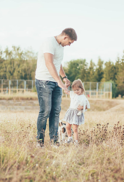 papá, hija y perro están paseando en el parque - Foto, Imagen