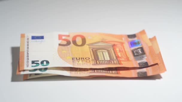 Vídeo conceptual del pago en efectivo con billetes en euros colocados sobre una mesa, aislados sobre fondo blanco. - Metraje, vídeo