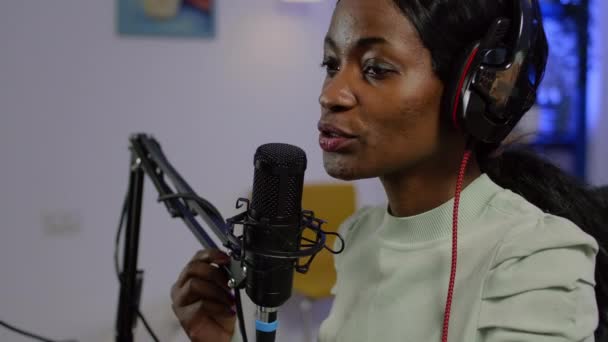 Μαύρο vlogger στον αέρα κατά τη διάρκεια του podcast καναλιού με χρήση mixer ελέγχου ήχου - Πλάνα, βίντεο