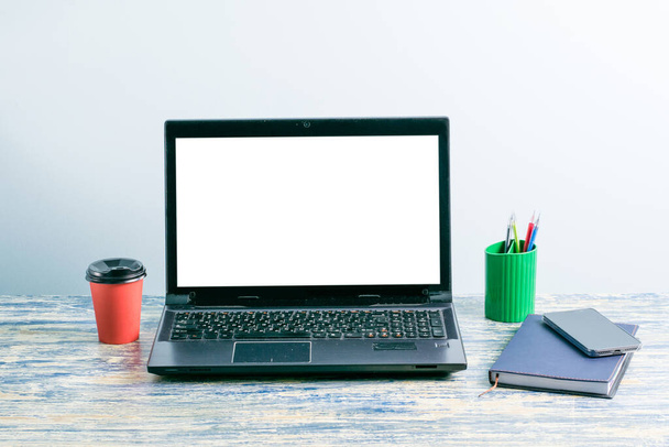 Local de trabalho com cabeçalho mockup na tela do laptop, smartphone, notepad e canetas, café ou chá em xícara de papel na mesa. - Foto, Imagem
