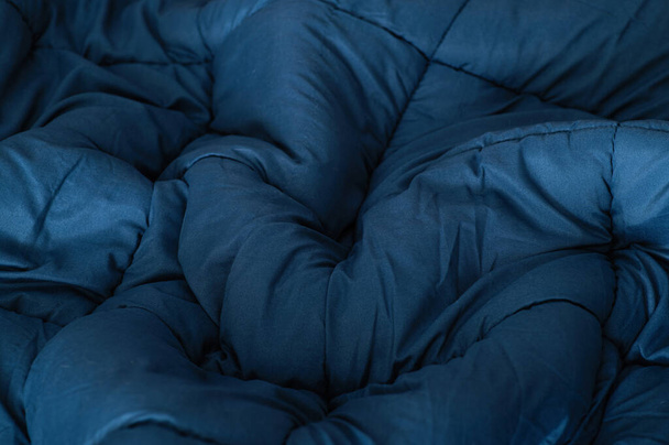 blauwe deken verspreid over het bed, textuur, bovenaanzicht - Foto, afbeelding