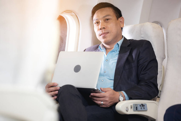 liikemies, jolla on muistikirja ja joka istuu lentokoneessa - Valokuva, kuva
