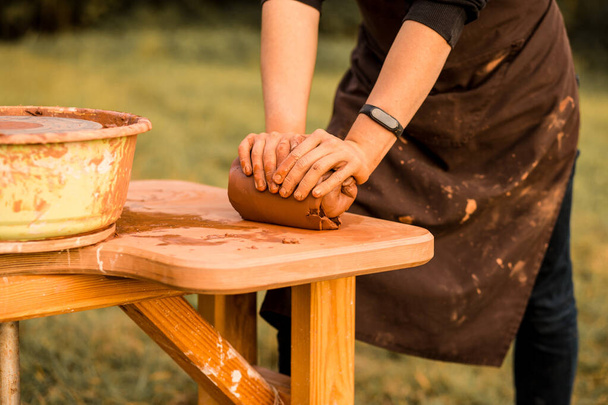 Le mani di artigiano impastano l'argilla per fare la boccia di ceramica. Uomo che lavora sulla ruota del vasaio - Foto, immagini