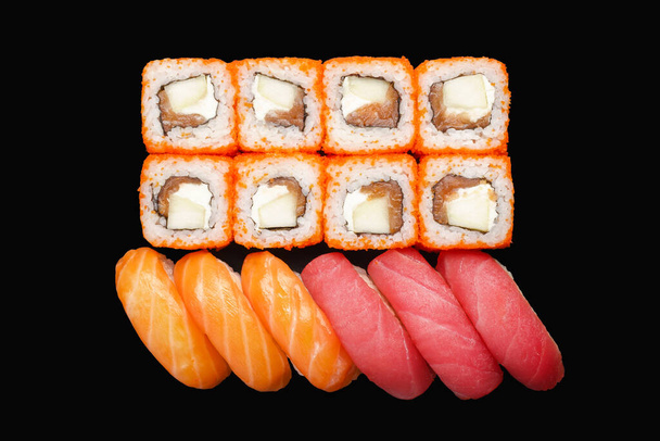 Sushi roll set met zalm, Philadelphia kaas, Masago kaviaar, appel. Nigiri zalm, nigiri tonijn. Geïsoleerd op zwarte achtergrond - Foto, afbeelding