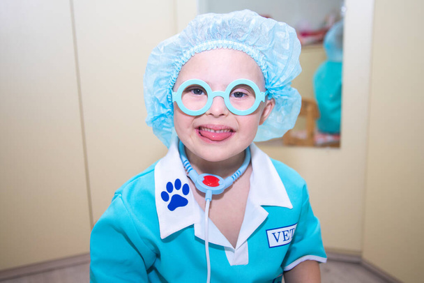 Boy with Down syndrome, portrait of a genetically ill disabled child in a doctor's costume, special children, genetic abnormalities. - Photo, Image