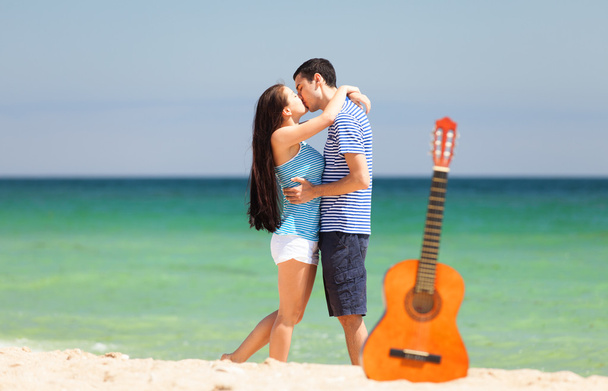 Coppia giovane con chitarra in spiaggia in estate
. - Foto, immagini