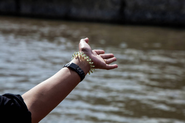 Donna mano e braccio disteso da una barca fluviale in movimento - Foto, immagini