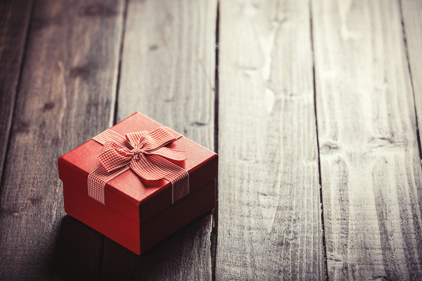 Червона подарункова коробка на дерев'яному столі
. - Фото, зображення