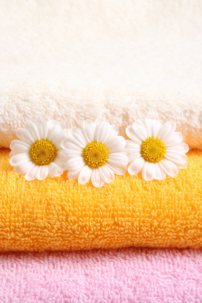 στοίβα πετσέτες και ωραίο marigolds - περιποίηση σώματος - Φωτογραφία, εικόνα