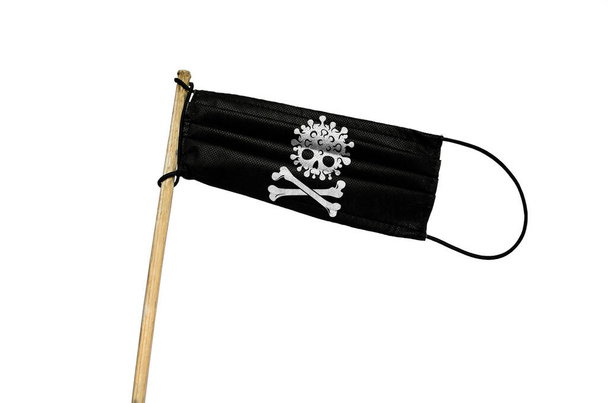 Het medisch masker wappert een vlag op een paal met COVID schedel en botten. Zwart geïsoleerd masker op witte achtergrond. Zwarte piratenvirus Aanval vlag. Concept van het coronavirus COVID-19 - Foto, afbeelding