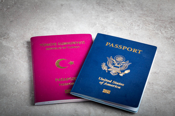 Bild eines US-Passes und eines türkischen Passes nebeneinander. Konzeptbild für die Einwanderung in die USA, den Weg zur Staatsbürgerschaft, die doppelte Staatsbürgerschaft, das Leben im Ausland und das Antragsverfahren für die US-Staatsbürgerschaft. - Foto, Bild