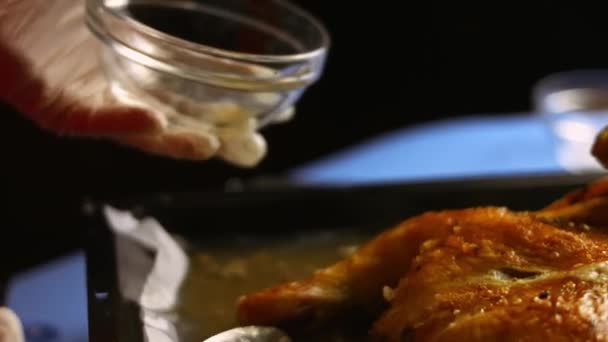 La chef recogiendo grasa derretida de un gran pollo asado al horno spatchcocked en una bandeja para hornear. El proceso de cocción shkmeruli - el plato georgiano. Disparo artístico - Metraje, vídeo