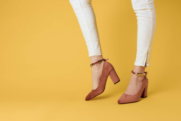 Női láb divatos cipő luxus sárga háttér elegáns stílus - Fotó, kép