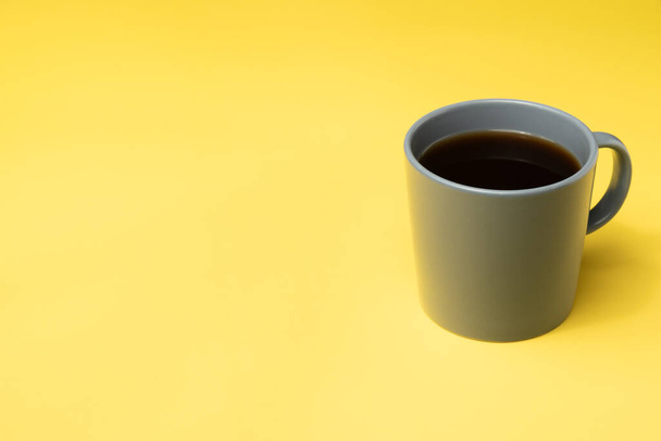 Tasse à café grise sur fond jaune. - Photo, image
