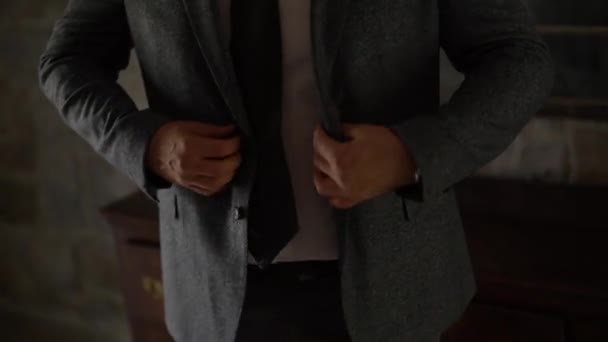 Un homme en costume gris redresse et boutonne sa veste - Séquence, vidéo