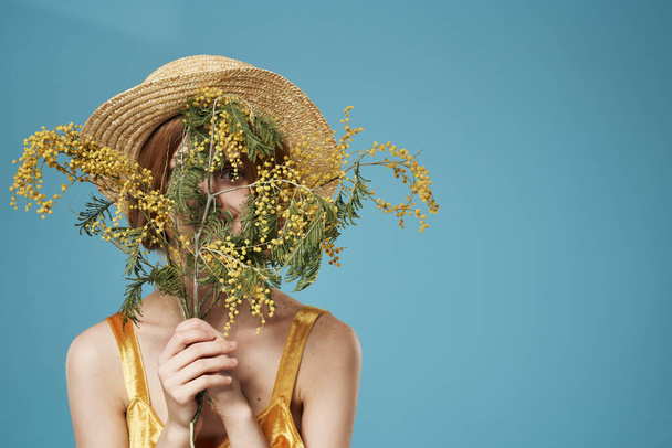Femme en chapeau avec un bouquet de fleurs vacances femmes jour charme fond bleu - Photo, image