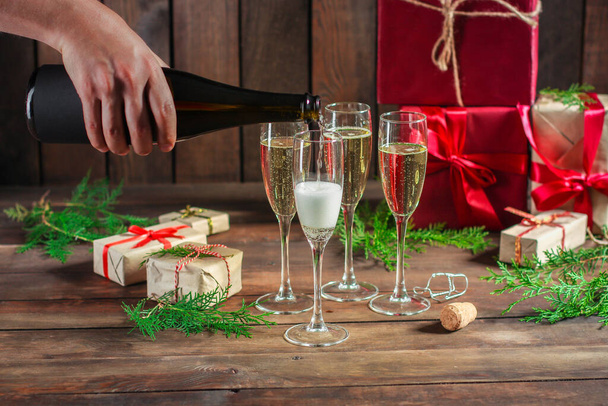 Şampanyalı şarap şişesi ve tahta arka planda hediye kutusu. - Fotoğraf, Görsel