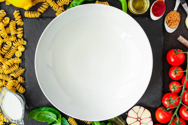 вид сверху на ингредиенты для макарон с белой тарелкой - Фото, изображение