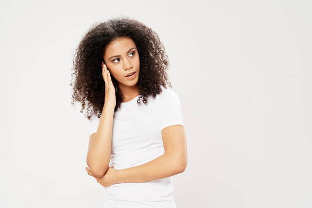 woman with curly hair in white t-shirt emotions studio self-confidence - Foto, Imagem