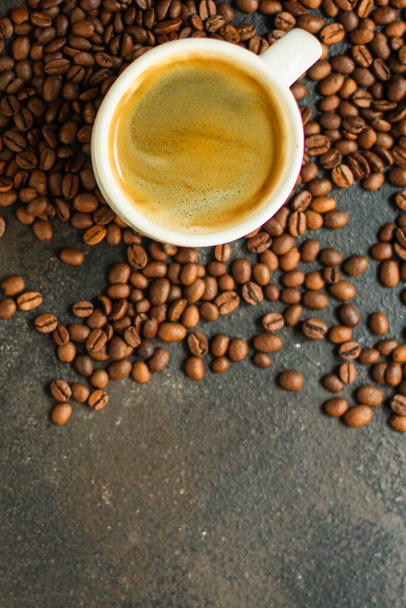 чашка кави зі смаженими бобами на темному фоні
  - Фото, зображення