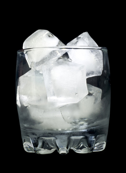 Refreshment: Glass with ice cubes over black background - Photo, image