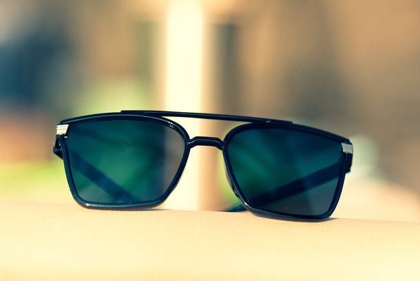 Überdimensionales Sonnenbrillenmodell mit großen schwarzen Gläsern schießt draußen in der Natur in einer Großaufnahme an einem Sommertag. Selektiver Fokus - Foto, Bild