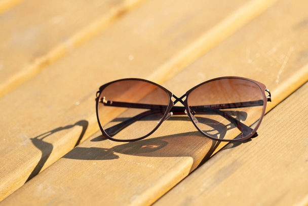 Bir yaz günü, doğada güneşi yansıtan özel tasarım çekimleri olan kadınlar için moda güneş gözlüğü modeli. Seçici odak - Fotoğraf, Görsel