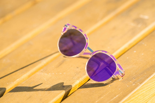 Fashion zonnebril model voor dames schieten buiten in een zomerse dag weerspiegelt de zon close-up. Selectieve focus  - Foto, afbeelding