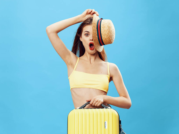 kobieta turysta z walizką stroje plażowe podróży niebieskie tło - Zdjęcie, obraz