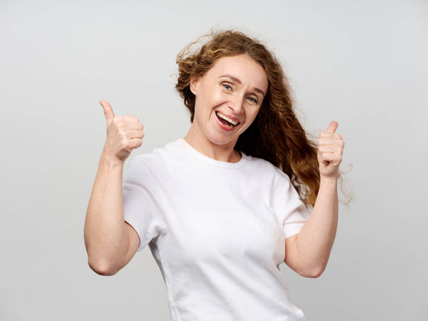 cheerful elderly woman in a white t-shirt gestures with her hands emotions - Foto, afbeelding