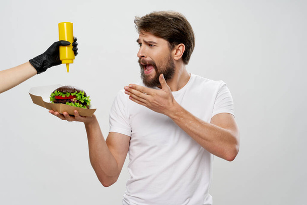man met baard met hamburger fast food mosterd dieet - Foto, afbeelding