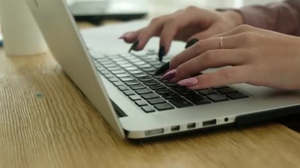 Επιχειρηματίας εργάζεται σε ένα γραφείο σε έναν υπολογιστή, πληκτρολογώντας κείμενο με τα δάχτυλά της. Η γραμματέας δακτυλογραφεί ένα έγγραφο σε ένα φορητό υπολογιστή. κοντινό πλάνο των χεριών πατώντας ένα κουμπί στο πληκτρολόγιο - Πλάνα, βίντεο