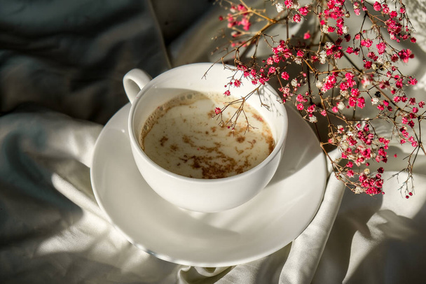 Fehér csésze tej és csokoládé. Reggeli esztétikai rezgések. Reggeli. Rózsaszín cigányvirág - Fotó, kép