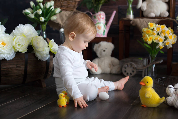 Cute toddler blond child, boy with easter decoration in studio, crawling on the floor - Fotoğraf, Görsel