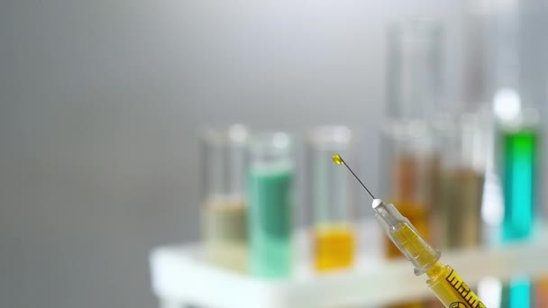 Close-up van een medische spuit gevuld met een medicijnvaccin tegen het virus. Behandeling en vaccinatie tegen coronavirus bij een pandemie. Medische bescherming van personen. - Video
