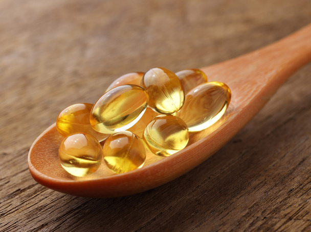 Fish oil capsules in a spoon - Фото, изображение