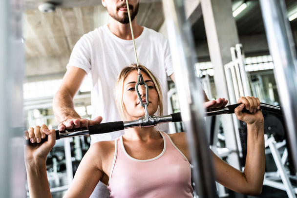 Smart sport women lift up barbell with trainer man in gym healthy concept - Photo, Image