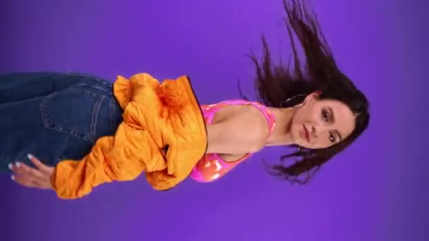 Spowolniony ruch stylowej młodej kobiety pozowanie odizolowany na fioletowy  - Materiał filmowy, wideo