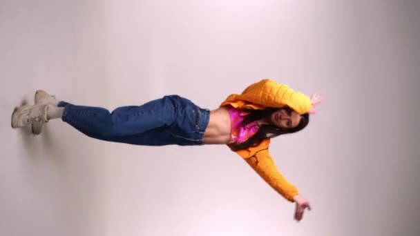 Movimiento lento de la bailarina con estilo que se mueve sobre fondo gris  - Imágenes, Vídeo