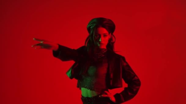Slow motion of young woman dancing on red background with green light - Záběry, video