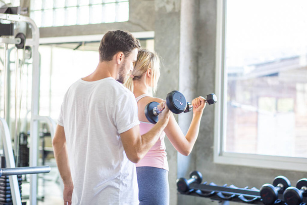 Pareja deportiva hacen levantamiento de pesas juntos en el gimnasio loft estilo de vida saludable - Foto, imagen