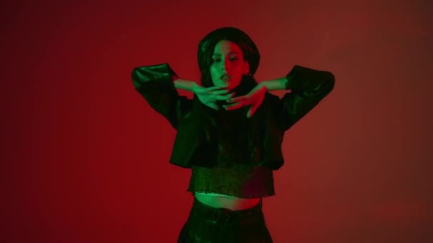 Brünette Frau tanzt auf rotem Hintergrund mit grünem Licht  - Filmmaterial, Video