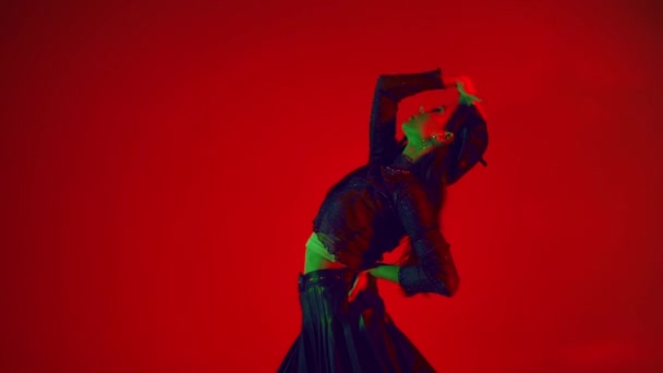 Zwolniony ruch stylowej kobiety poruszającej się na czerwonym tle  - Materiał filmowy, wideo