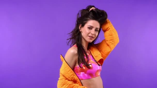 Cheerful and stylish woman dancing isolated on purple  - Footage, Video