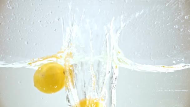 Sarı olgun limonlar beyaza dökülüyor. - Video, Çekim