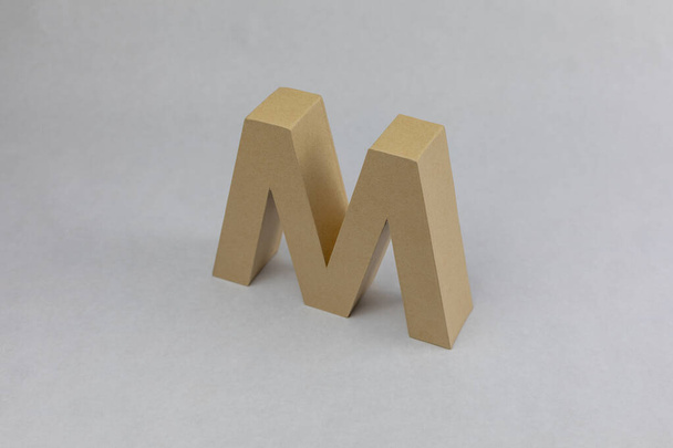 Letra M hecha en cartón sobre fondo blanco elegante letra m - Foto, imagen