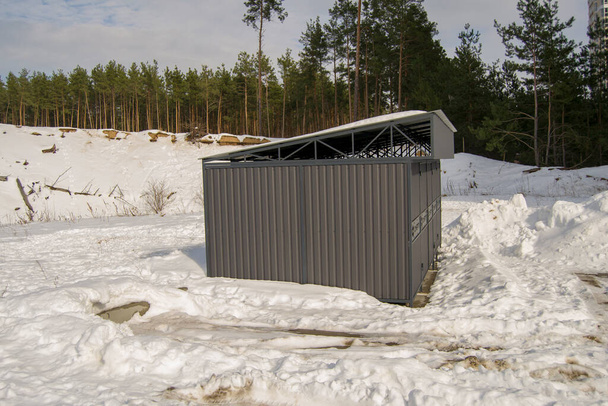 structure métallique pour conteneurs de déchets. locaux près de bâtiments résidentiels. développement d'infrastructures dans un immeuble d'habitation neuf. le sol est couvert de neige - Photo, image